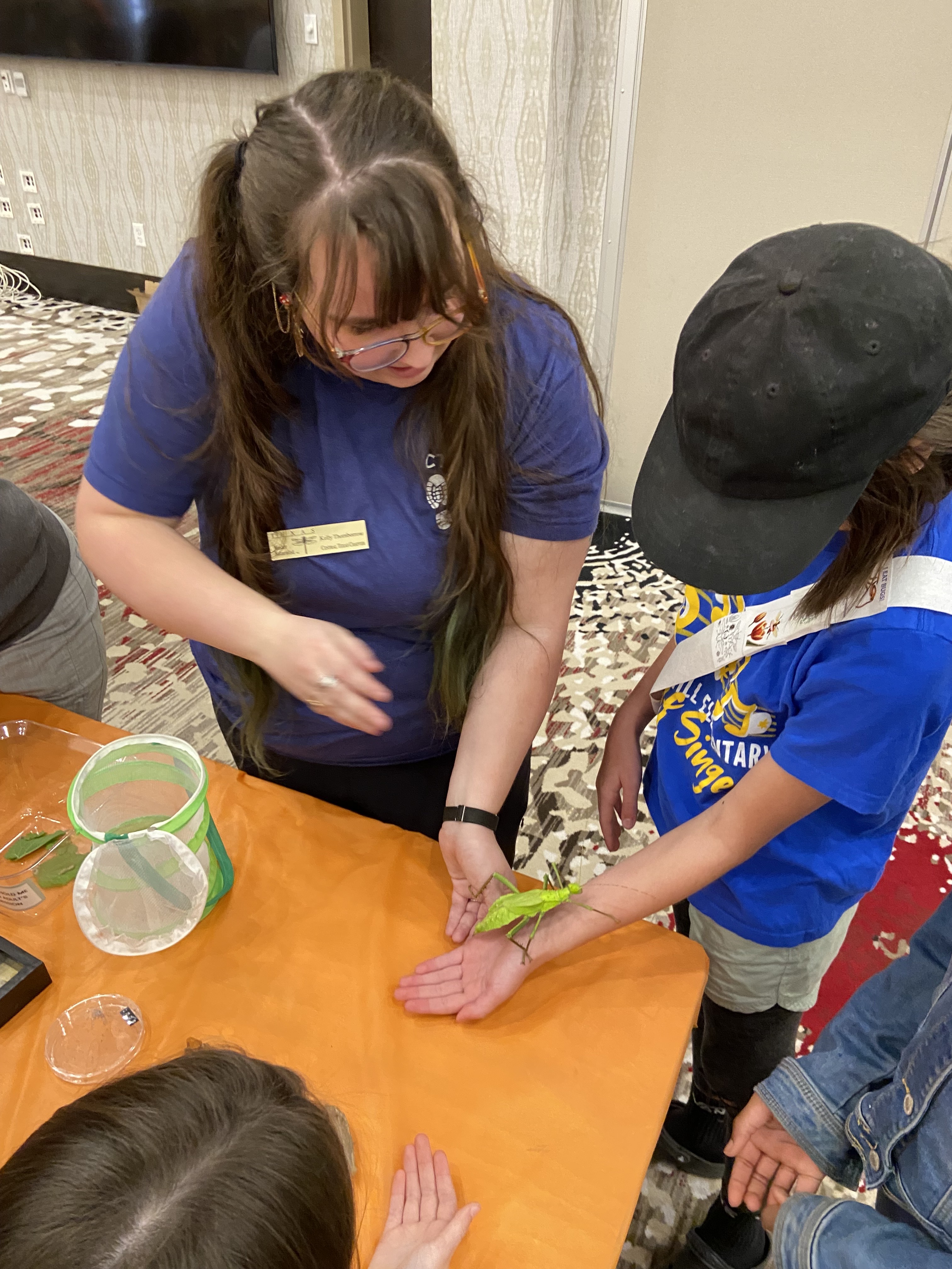 woman with long hair showing kid insect