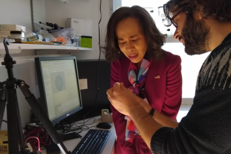 Two people stand next to a desk with a computer and technical equipment. One, possibly a Science Policy Fellow, explains or demonstrates something—highlighting how entomologists can advocate for their discipline in federal policy in Washington, D.C.