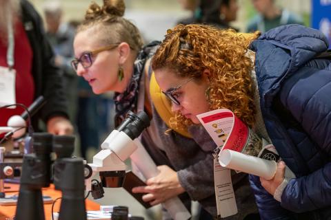 exhibit hall, two people looking in microscopes